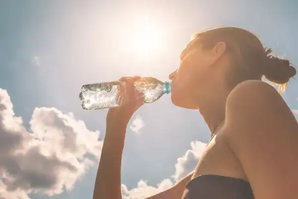 Hydration: The Secret Ingredient for a Toned Stomach and Enhanced Fitness 3 Image of woman drinking water to hydrate Rochester after run.